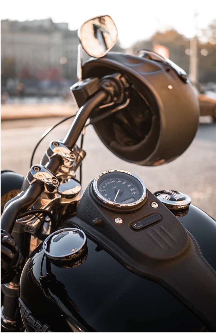 Black Motorcycle dash and black helmet hanging on the handle
