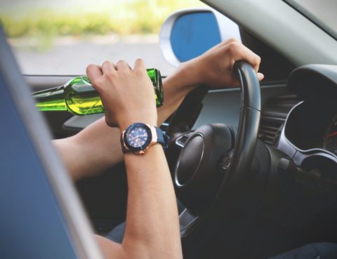driving while holding a green bottle of beer